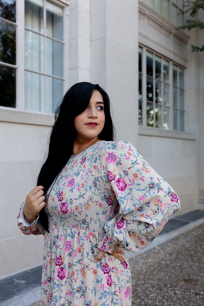 Long-sleeve floral print maxi dress with pink and purple flowers, modeled outdoors against a historic stone wall