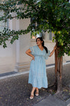 Woman wearing light blue boho midi dress with flutter sleeves