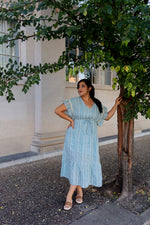 Woman wearing light blue boho midi dress with flutter sleeves