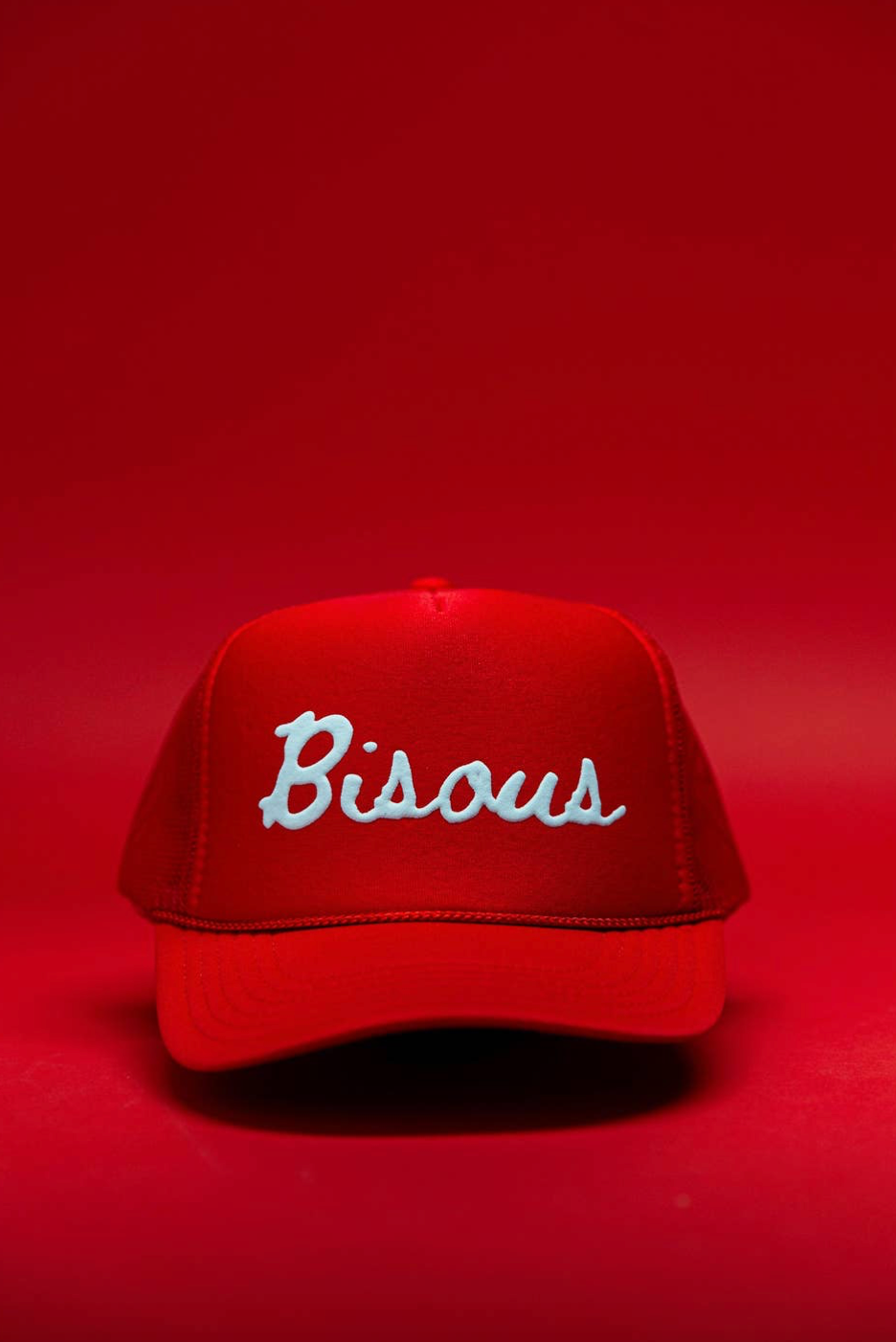 Red cap with 'Bisous' embroidery on a red background