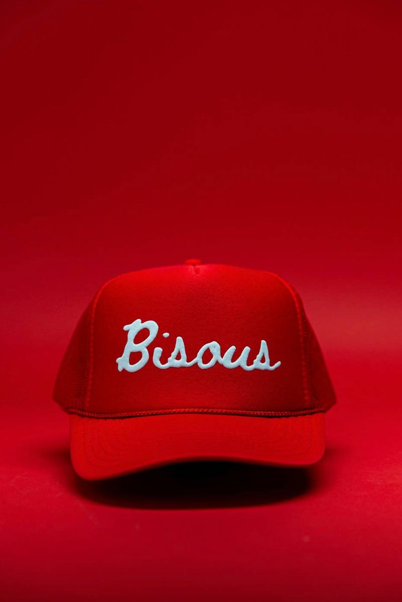 Red cap with 'Bisous' embroidery on a red background