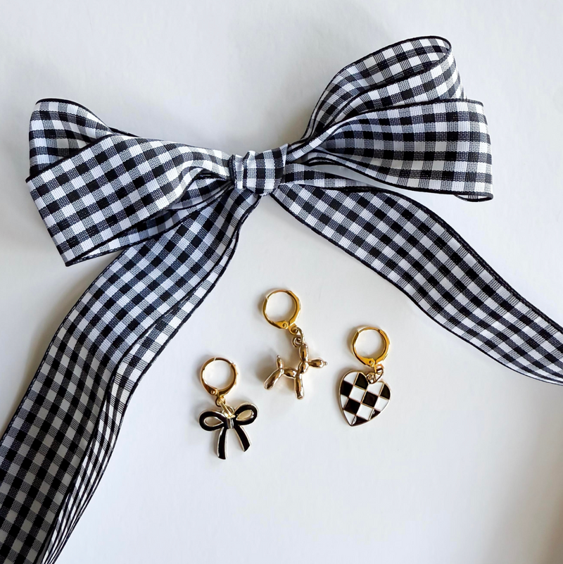 Black and white checkered headband with three gold earrings on a white card featuring 'Leo + Lee' brand.