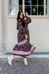 Woman in a floral dress standing outside a building