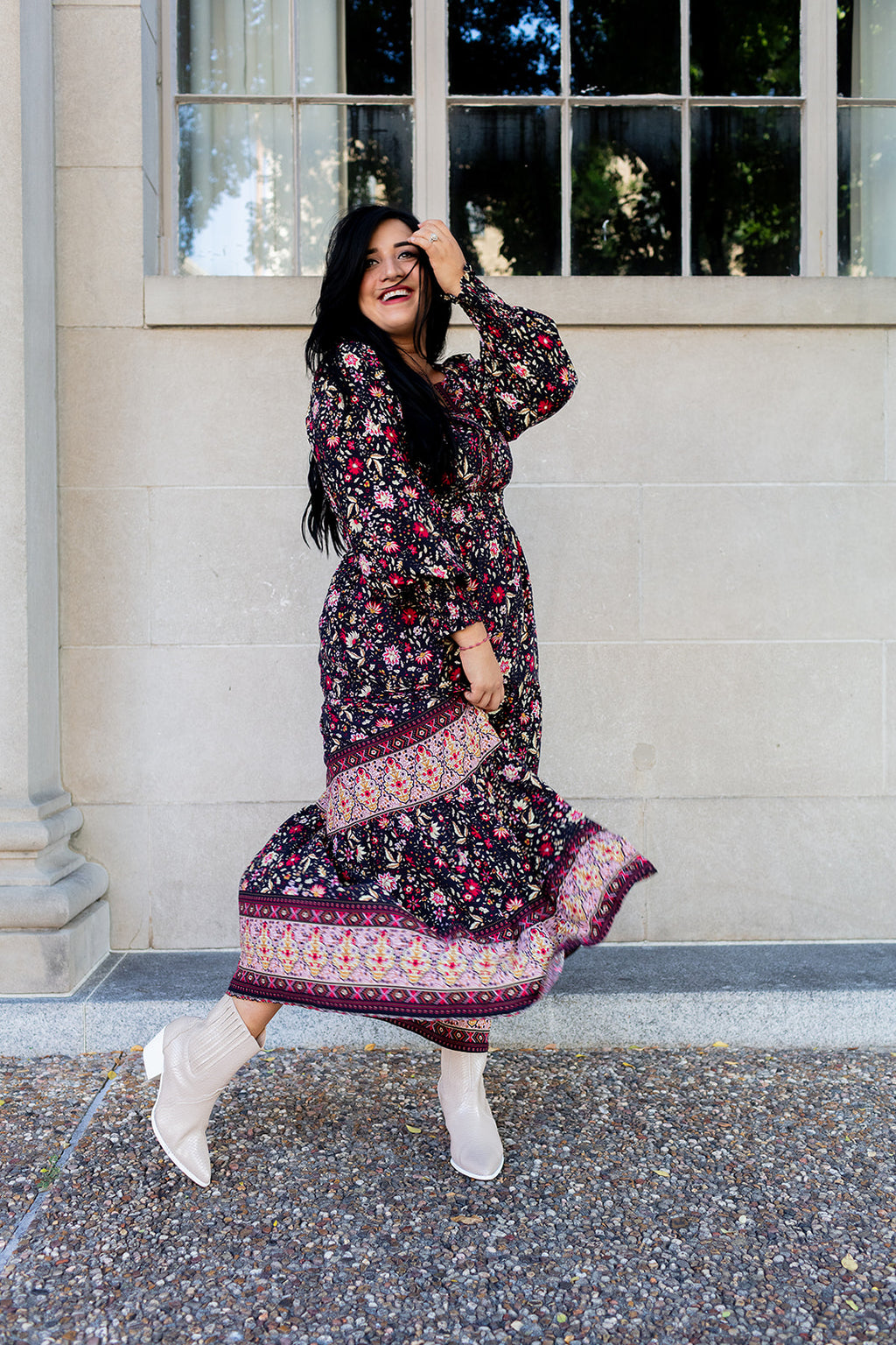 Woman in a floral dress standing outside a building