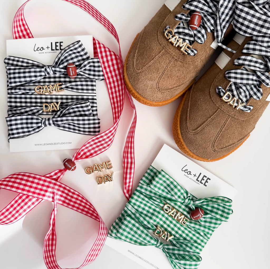 Brown shoes with 'Game Day' accessories, including bows and ribbons, on a white background.