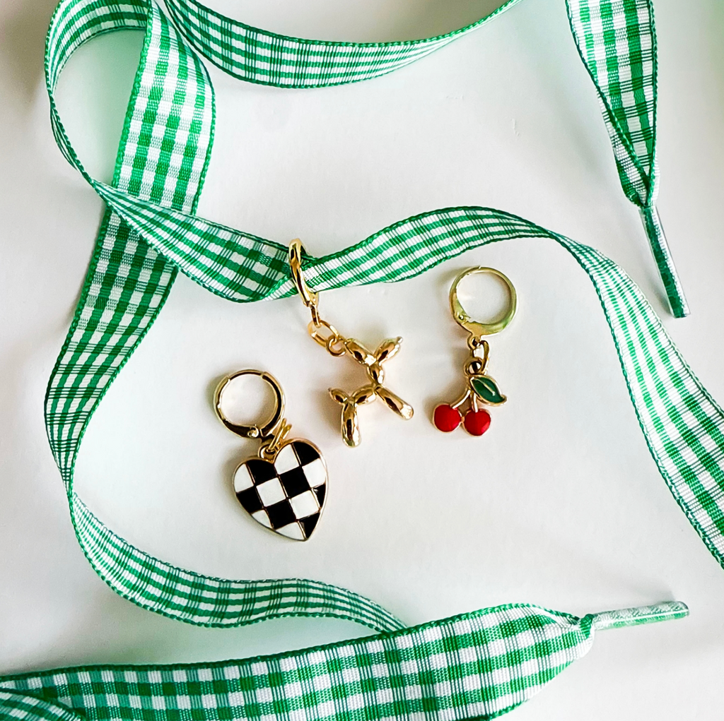 Three keychains with green and white checkered ribbon