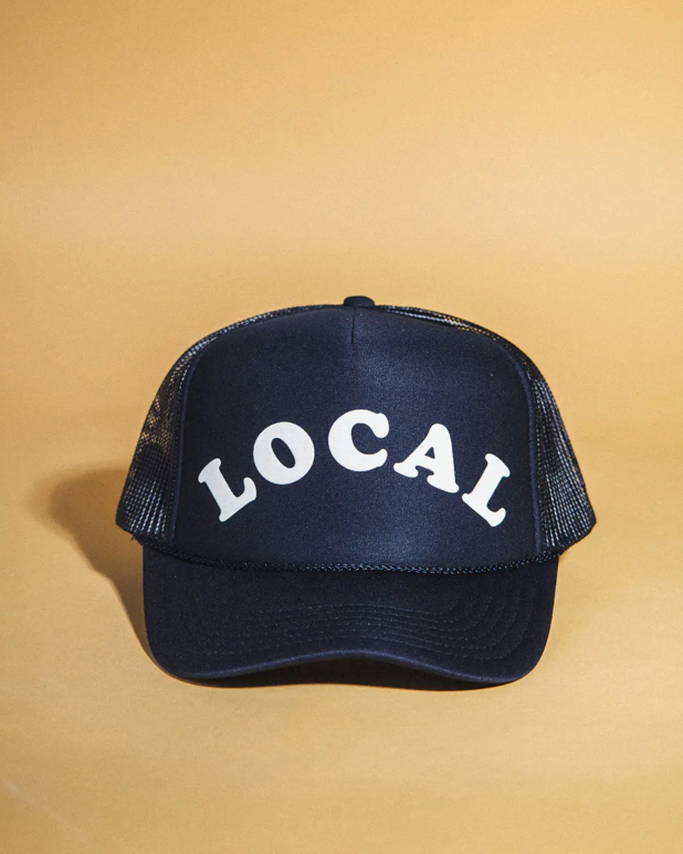 Navy blue cap with 'LOCAL' text on a beige background