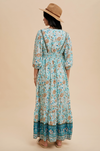 Woman wearing a floral dress and hat on a beige background