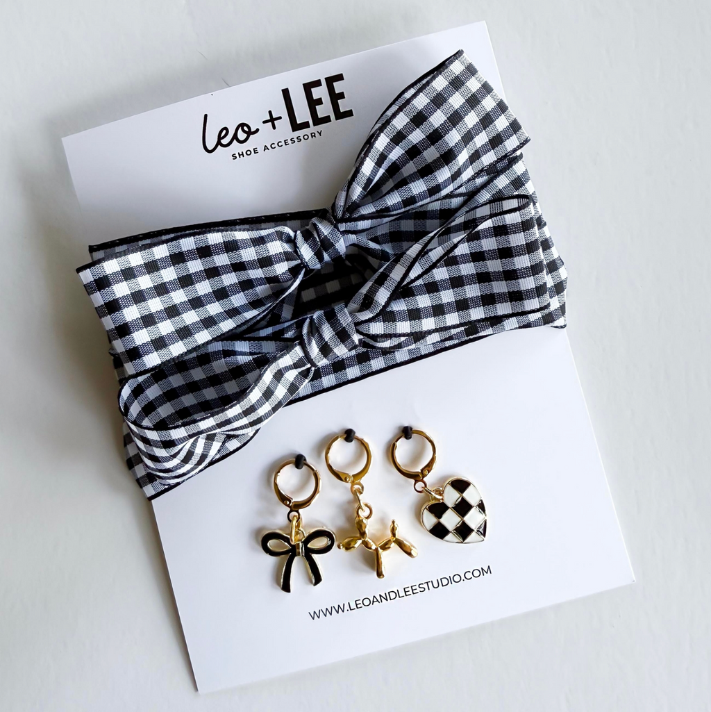 Black and white checkered headband with three gold earrings on a white card featuring 'Leo + Lee' brand.